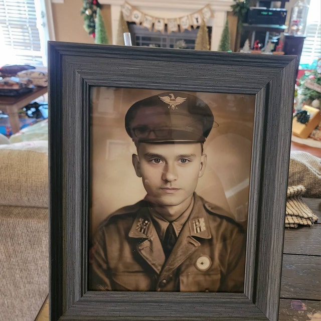 Framed aviator portrait on a living room shelf