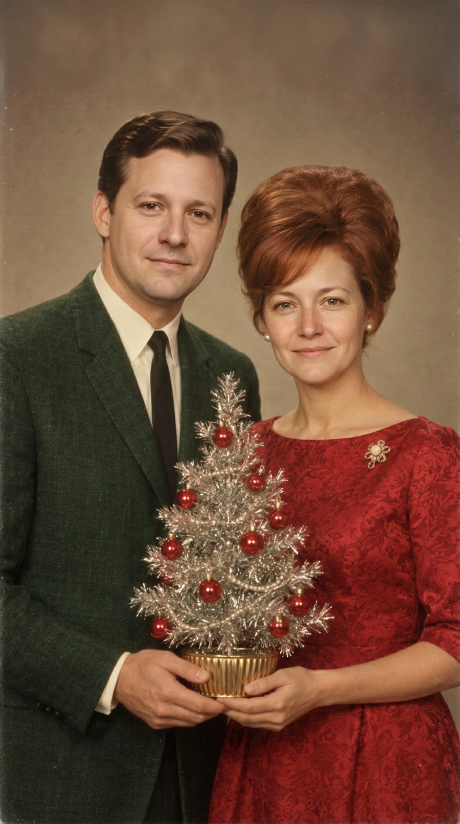 A couple restyled as a 1960s Christmas portrait, holding a small tinsel tree
